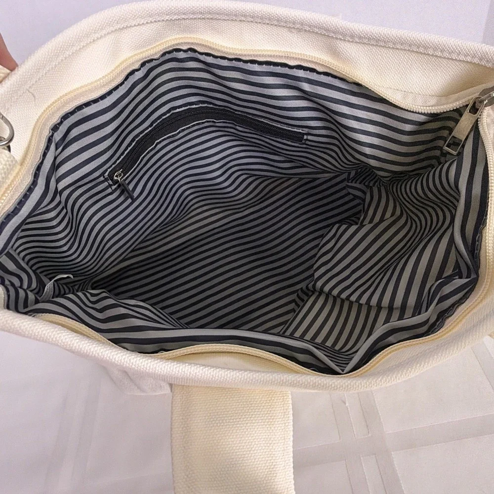 iNN BEAUTY bag off white tote bag with black letter branded straps.